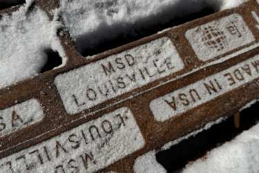 A catch basin covered in snow 