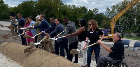 Officials tossing shovels of sand at groundbreaking ceremony