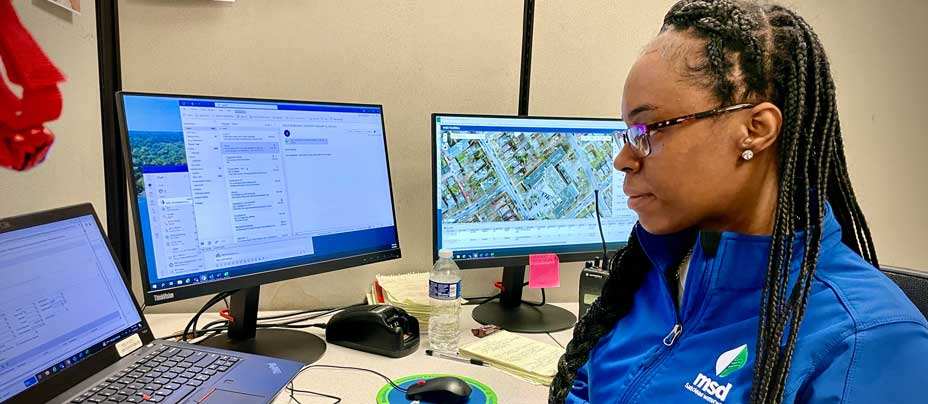 Female MSD employee reviewing multiple computer screens